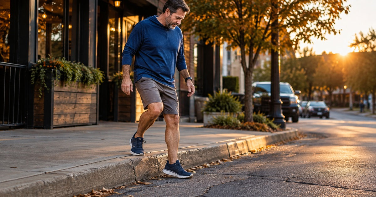 Adult man stepping from a curb onto uneven pavement while managing repeat ankle sprain risk